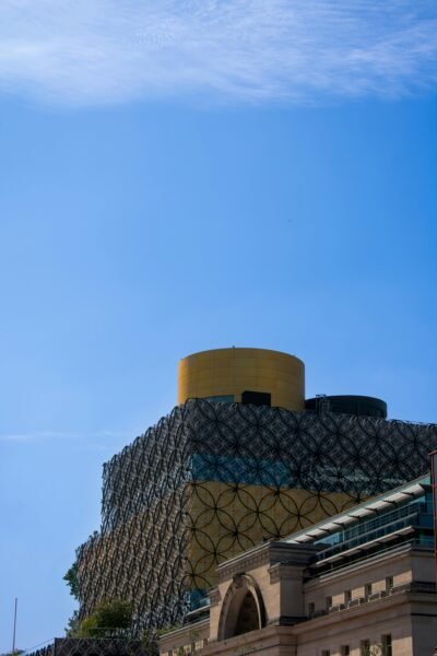 Modern architecture of Birmingham Library against a clear blue sky, showcasing intricate design.